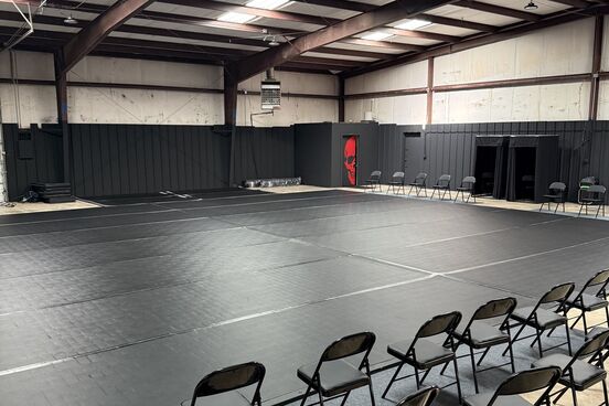 The full mat space at 13th Chamber, with seating along the edge for visitors.